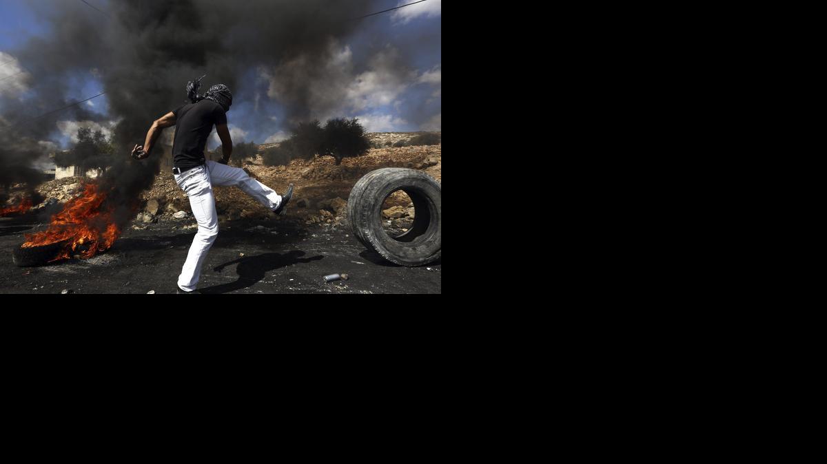 <cutline_leadin>Un manifestante</cutline_leadin> palestino patea una rueda durante una protesta contra el asentamiento judío de Qadomem en el pueblo de Kofr Qadom, Cisjordania, el viernes.