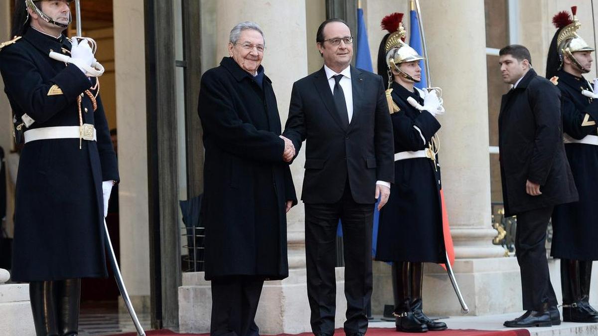 El presidente francés François Hollande (izq.) saluda al gobernante cubano Raúl Castro en la entrada del Palacio del Elíseo en París, el lunes 1ro de febrero.