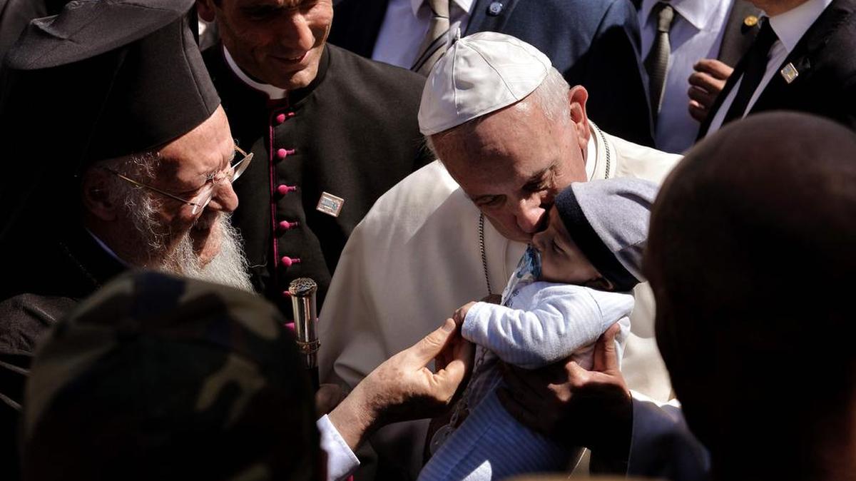 Papa Francisco besa a un niño en el centro de detención de Moria en Mitilene el 16 de abril de 2016. Francisco recibió una acogida emocional en la isla griega de Lesbos durante una visita el objetivo de mostrar la solidaridad con los migrantes que huyen de la guerra y la pobreza.