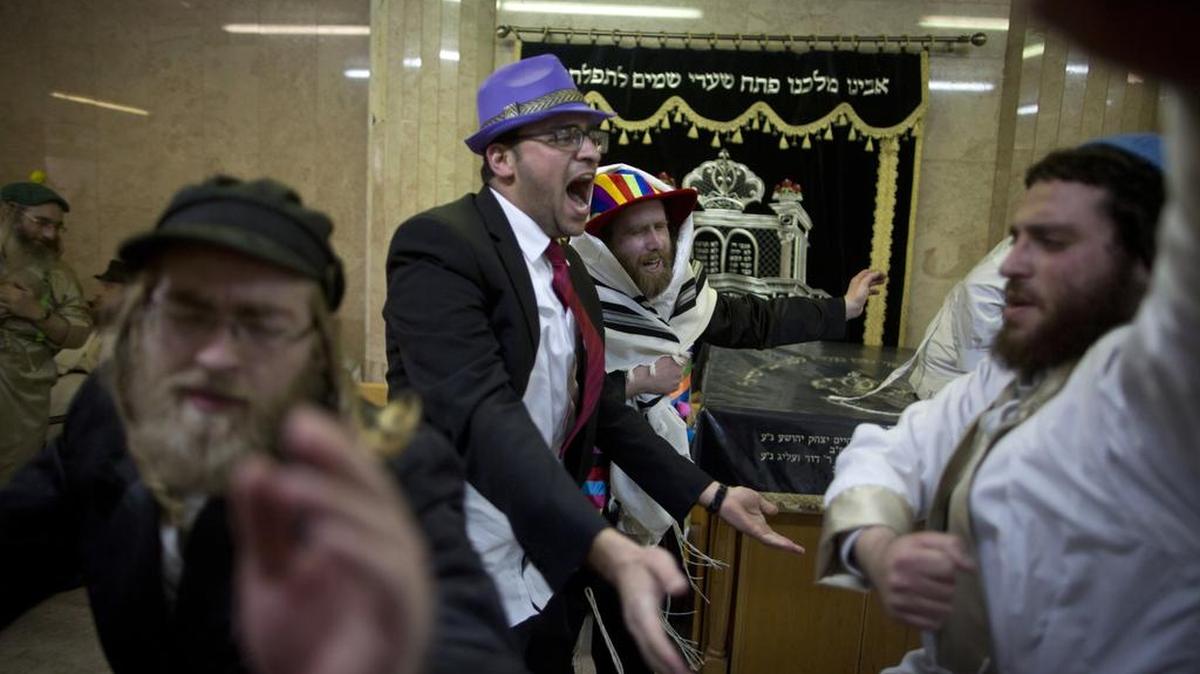 Hombres judíos ultra-ortodoxos celebran después de beber en el barrio ultraortodoxo de Mea Shearim el 25 de marzo de 2016 en Jerusalén, Israel. La fiesta de Purim carnavalesco se celebra con desfiles y fiestas de disfraces para conmemorar la liberación del pueblo judío de una parcela de exterminarlos en el antiguo imperio persa hace 2,500 años, tal como se describe en el libro de Ester.