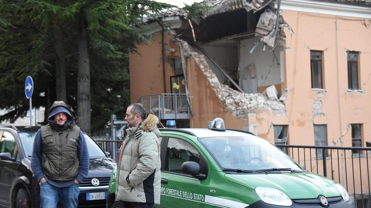 Miembros de los servicios de rescate permanecen frente a un edificio destruido en Visso, Italia, hoy, 27 de octubre de 2016.
