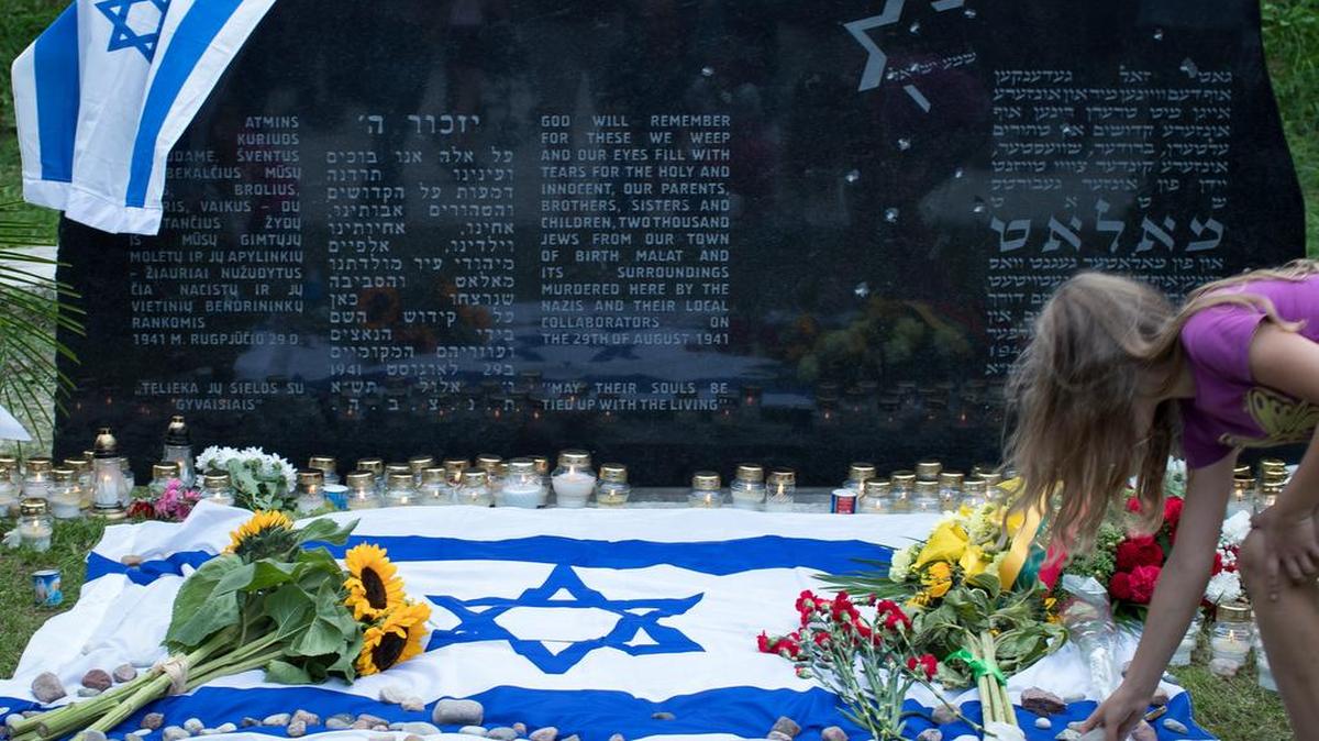 Una mujer coloca una piedra en el Memorial del Holocausto, durante la conmemoración del 75 aniversario de la masacre de unos 2,000 judíos por los nazis, en Lituania.