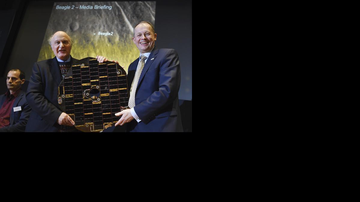 <cutline_leadin>El profesor</cutline_leadin> Mark Sims (izq.) de la Universidad de Leicester y el director ejecutivo de la Agencia Espacial Británica, el doctor David Parker, muestran un panel original de la Beagle-2 en Londres, Reino Unido, el viernes.<252><252>