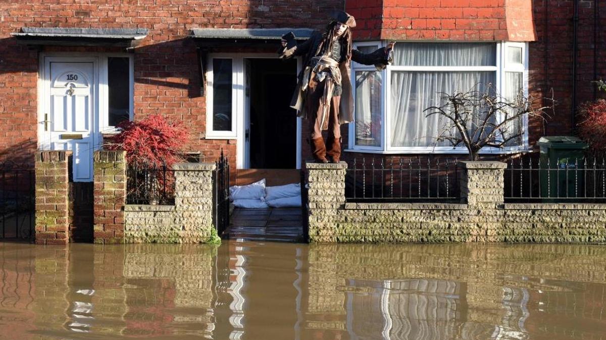 Un vecino vestido como el capitán Jack Sparrow, de la película ‘Pirates of the Caribbean’, frente a su casa inundada en York, Inglaterra, este domingo.
