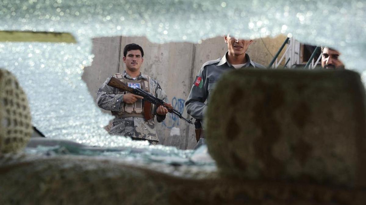 
Miembros de los servicios de seguridad afganos permanecen en guardia en el lugar donde se llevó a cabo una emboscada en Kandahar, Afganistán, el jueves. 

