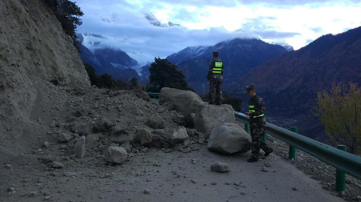 En esta foto publicada por la Agencia de Noticias Xinhua de China, los rescatistas observan un camino bloqueado por rocas caídas en la ciudad de Paizhen, Tíbet, al suroeste de China, el sábado 18 de noviembre de 2017.