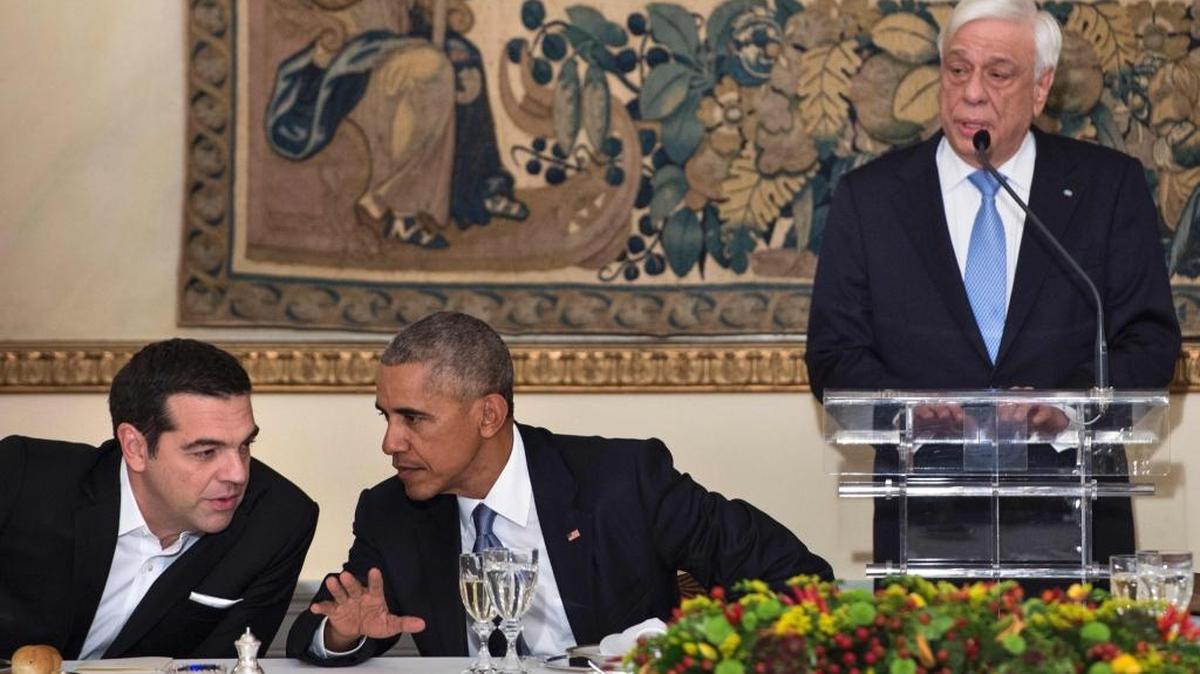 El primer ministro griego, Alexis Tsipras (izq.) y el presidente Barack Obama hablan durante la intervención del presidente griego Prokopis Pavlopoulos como antesala a la cena de estado.