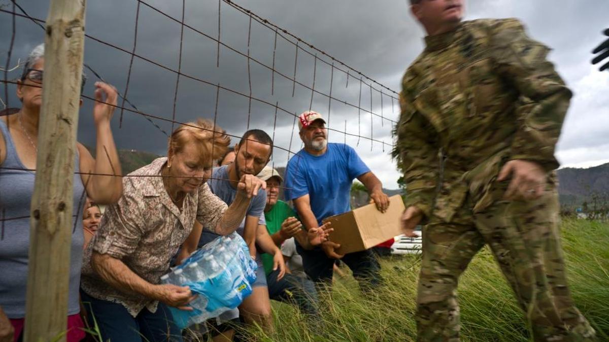 Un miembro de la Guardia Nacional en Puerto Rico lleva agua y alimentos a víctimas del huracán María.