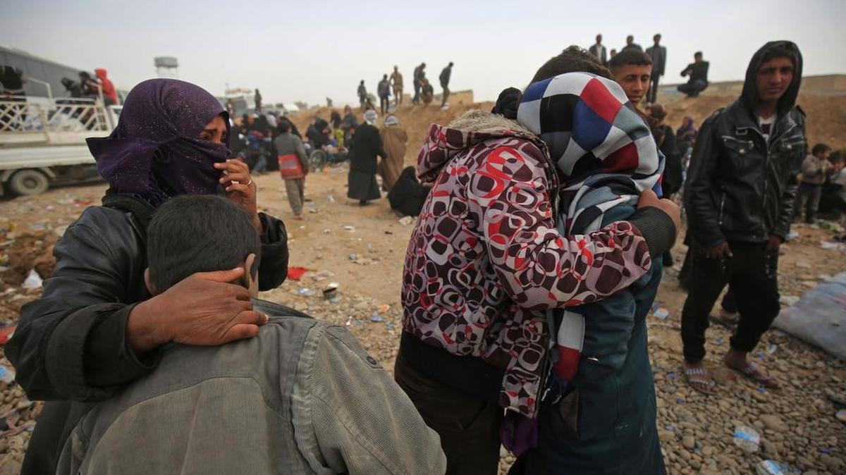 Una mujer iraquí desplazada de la ciudad de Mosul se reúne con su familia después de su llegada a un campamento en el área de Hamam al-Alil, al sur de la asolada ciudad el 11 de marzo de 2017.