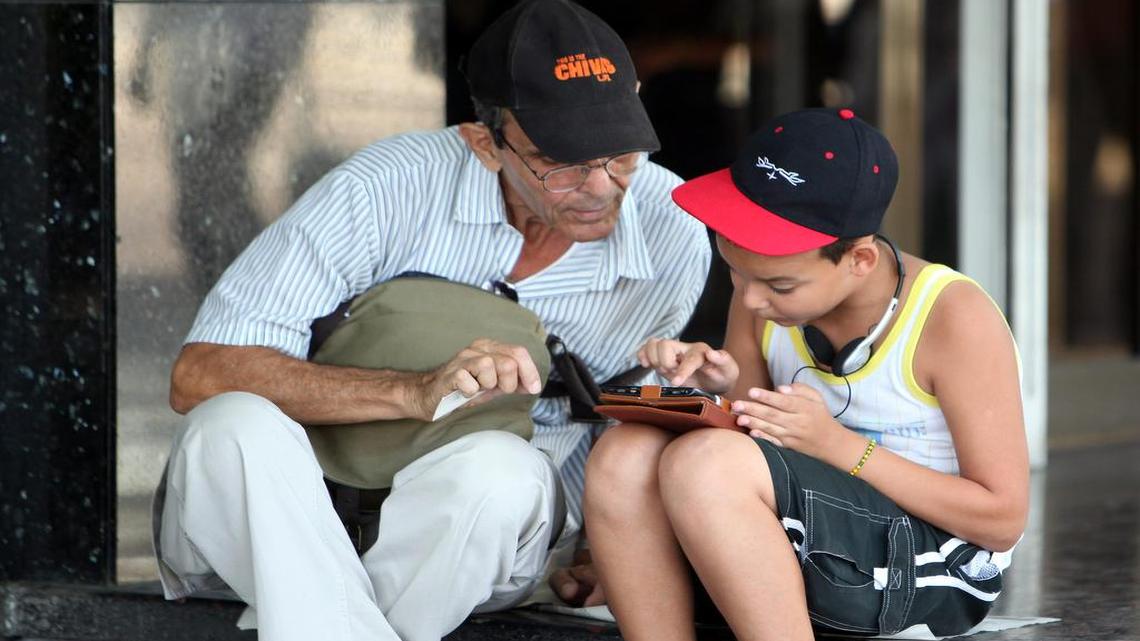 
Dos personas navegan por la internet en un dispositivo móvil, en una de las zonas habilitadas con Wifi en La Habana (Cuba). Los cubanos navegan por internet en móviles y "tablets" a lo largo de La Rampa, una de las principales avenidas de la capital, una estampa nada habitual en Cuba pero que ya es posible en los nuevos espacios wi-fi habilitados esta semana en 35 zonas públicas de la isla.
