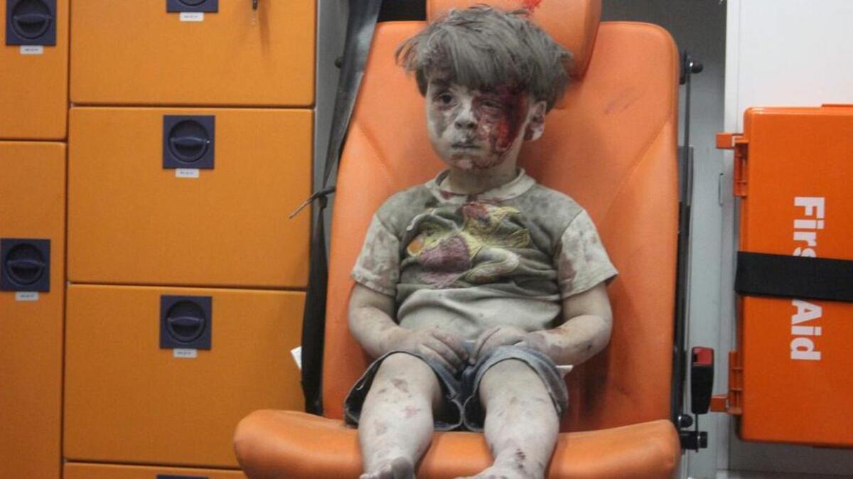 Imagen facilitada por el grupo activista Centro de Información de Alepo (AMC) el 18 de agosto de 2016 que muestra a un niño herido de 5 años, sentado en una ambulancia tras ser rescatado anoche de una vivienda bombardeada en el barrio de Al Qatergui en la ciudad siria de Alepo, ayer.