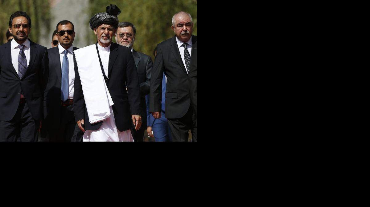 
El presidente afgano electo Ashraf Ghani (centro) arriba a la ceremonia de posesión en el palacio presidencial de Kabul.


