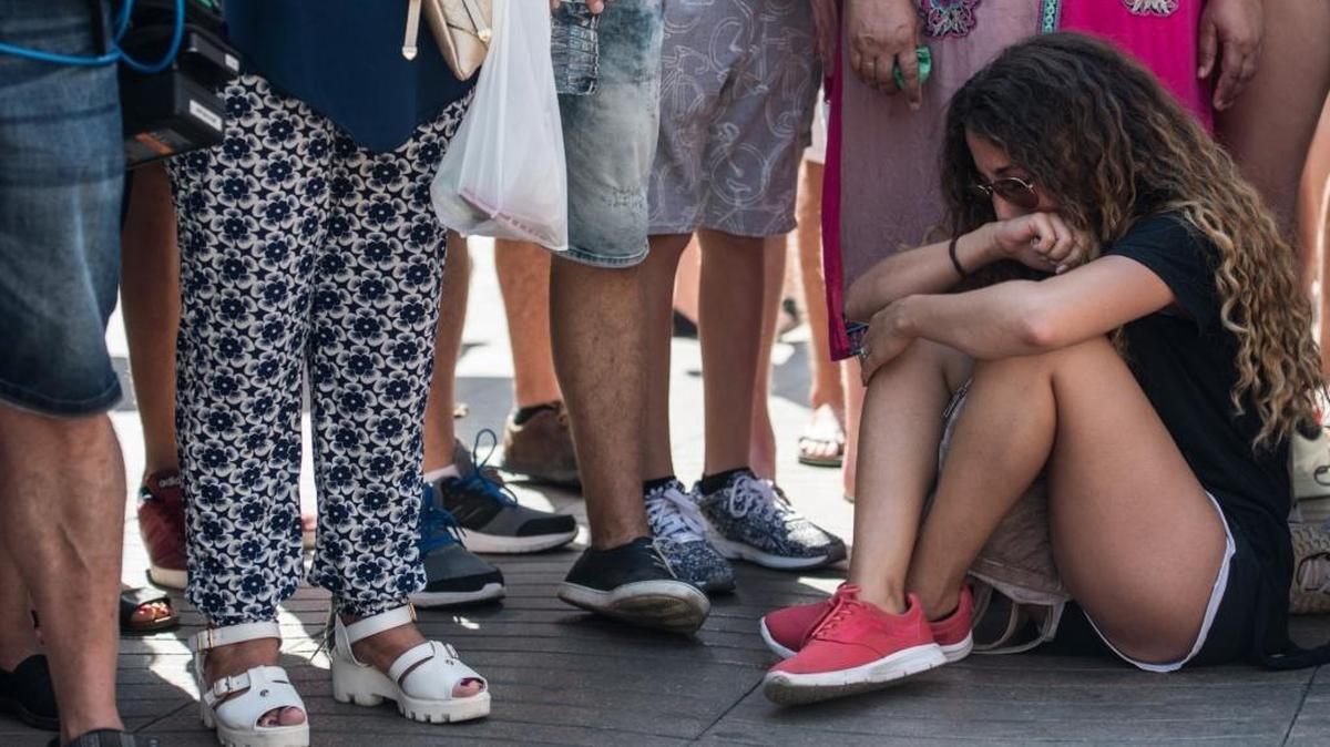 Una joven llora sentada en Las Ramblas, al día siguiente del atentado terrorista en Barcelona, en agosto del 2017.