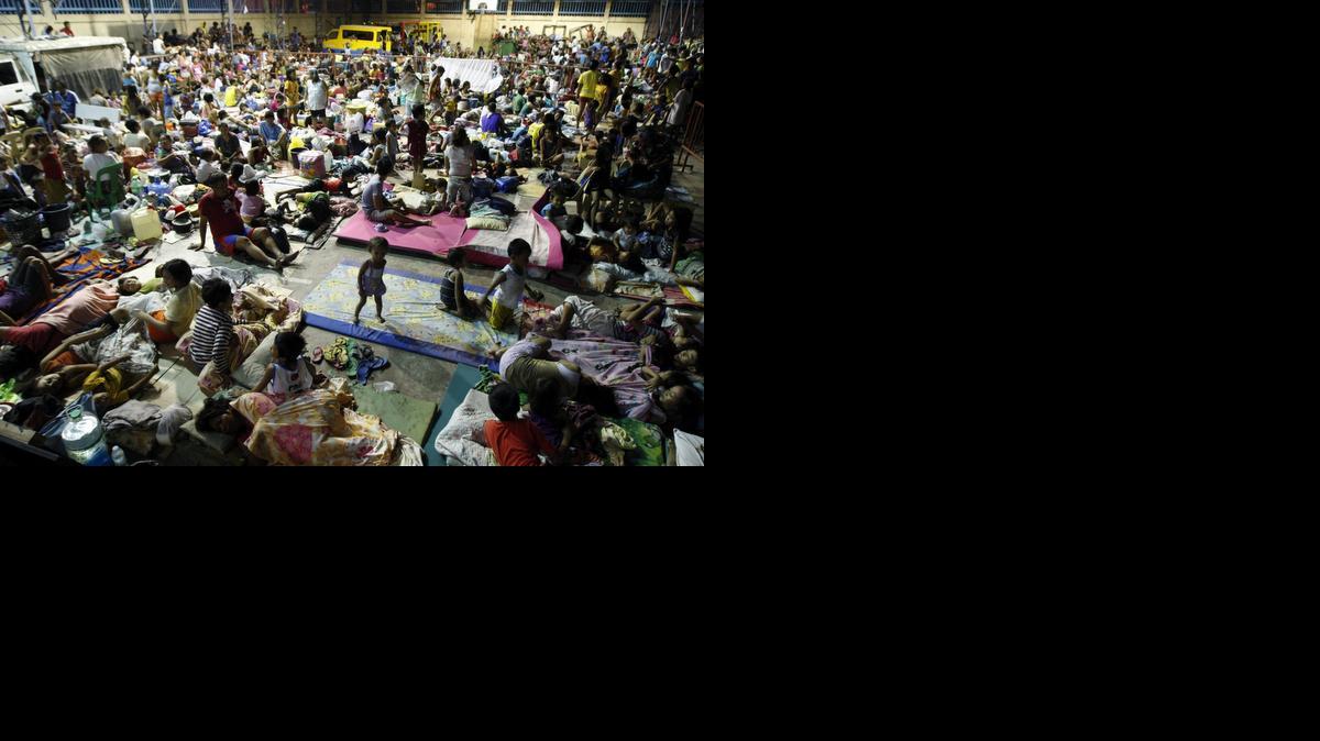 <cutline_leadin>Centenares de</cutline_leadin> personas se amontonan en un pabellón deportivo en la localidad de Mambaling, Filipinas, el viernes. Al menos medio millón de personas han buscado refugio en colegios, iglesias y centros de evacuación.<252><252>