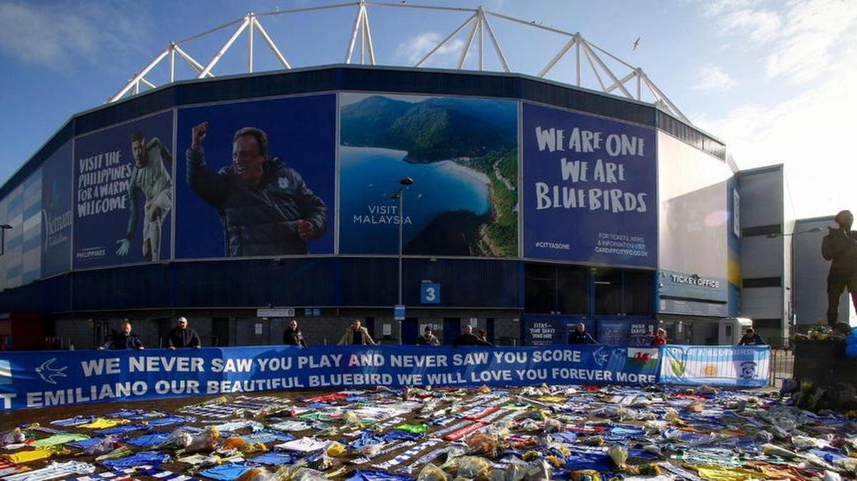 Las bufandas y camisetas de Cardiff City, flores, mensajes y otros tributos a Emiliano Sala, cuyo vuelo desapareció del radar sobre el Canal de la Mancha al norte de Guernsey, se observan frente al Estadio de la Ciudad de Cardiff en el sur de Gales el 25 de enero de 2019.