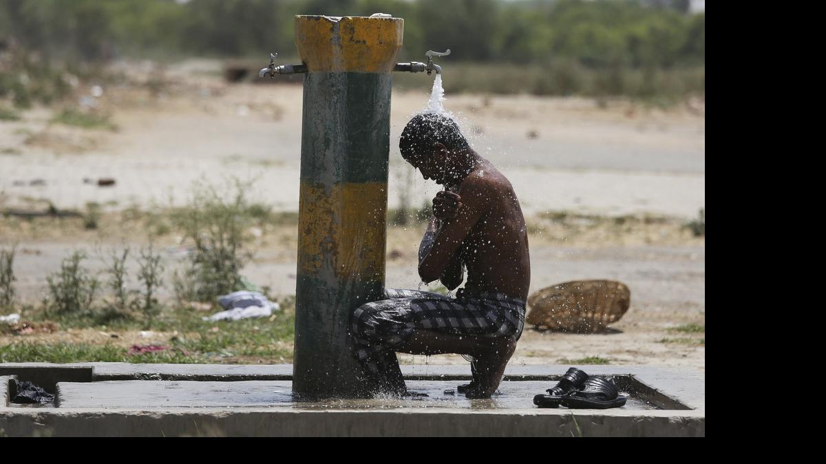 
 Un trabajador indio se refresca bajo un grifo una calurosa tarde en Amritsar (India), el martes 26 de mayo de 2015. 