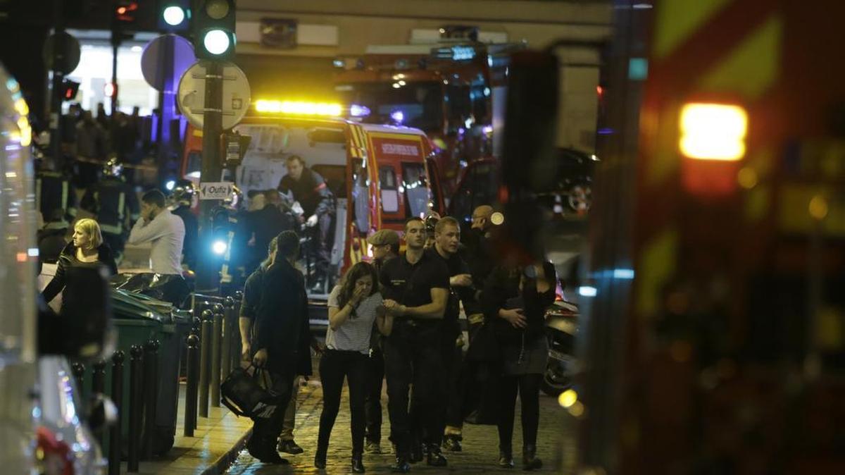 La seguridad francés corre mientras las personas son evacuadas en el área de Rue Bichat en el distrito 10 de la capital francesa de París tras una serie de ataques el 13 de noviembre de 2015.