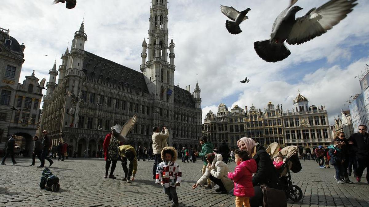 Palomas vuelan el lunes sobre turistas en the Grand Place en Bruselas.