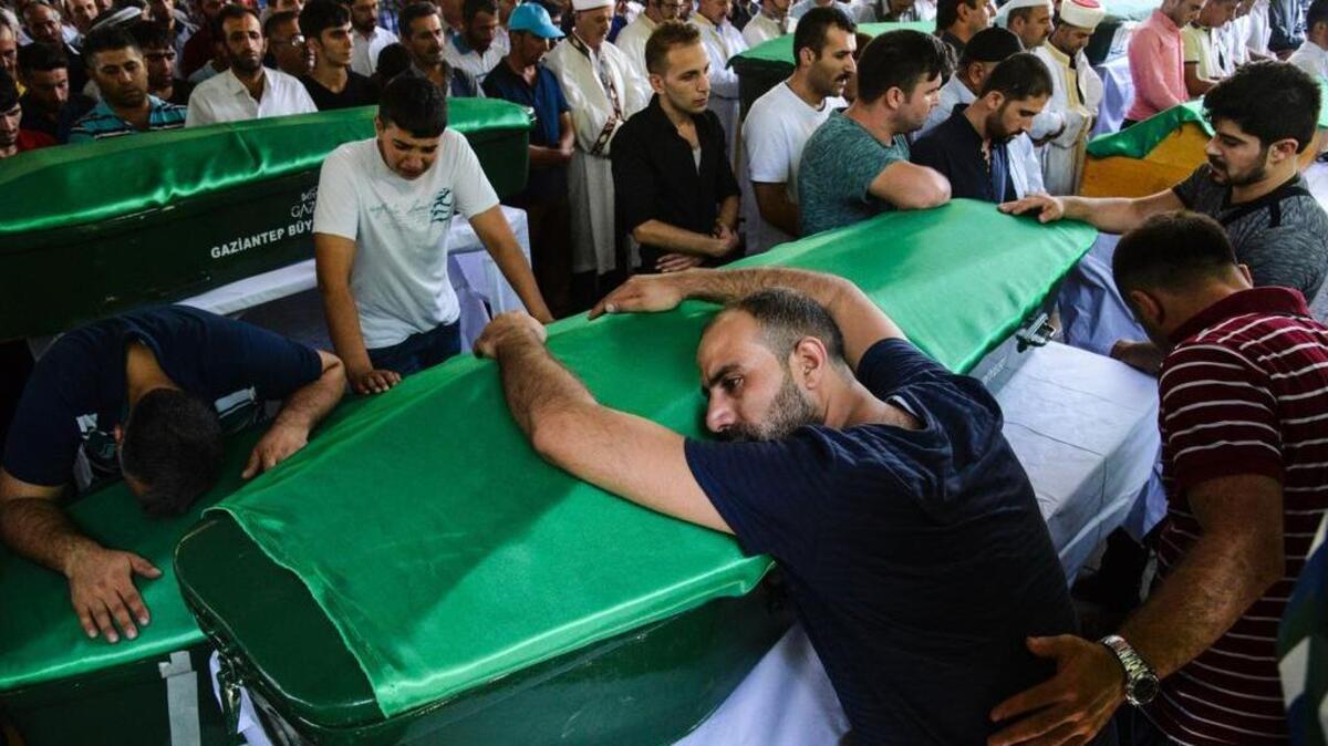Un hombre se inclina en un ataúd durante un funeral por las víctimas del atentado de anoche en una fiesta de boda que dejó 50 muertos en Gaziantep, en el sureste de Turquía, cerca de la frontera con Siria el 21 de agosto de 2016.