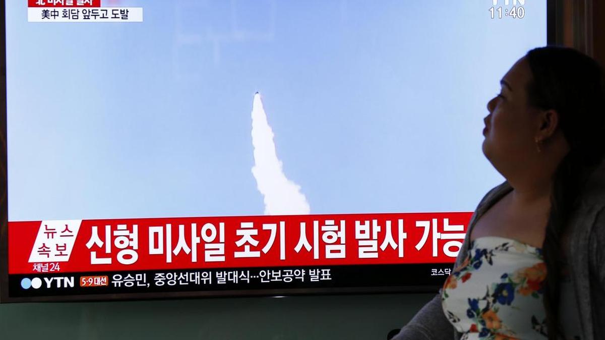 Una mujer surcoreana pasa por delante de una pantalla durante la transmisión televisada del lanzamiento por parte de Corea del Norte de un proyectil que podría ser un misil balístico en dirección al Mar del Este (Mar de Japón), en Seúl (Corea del Sur), el 5 de Abril de 2017.