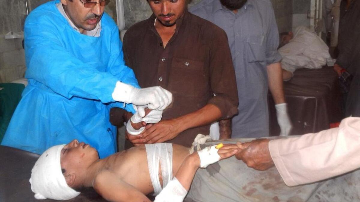 Paramédicos pakistaníes atienden a un niño herido luego del atentado suicida ocurrido en Butmaina.
