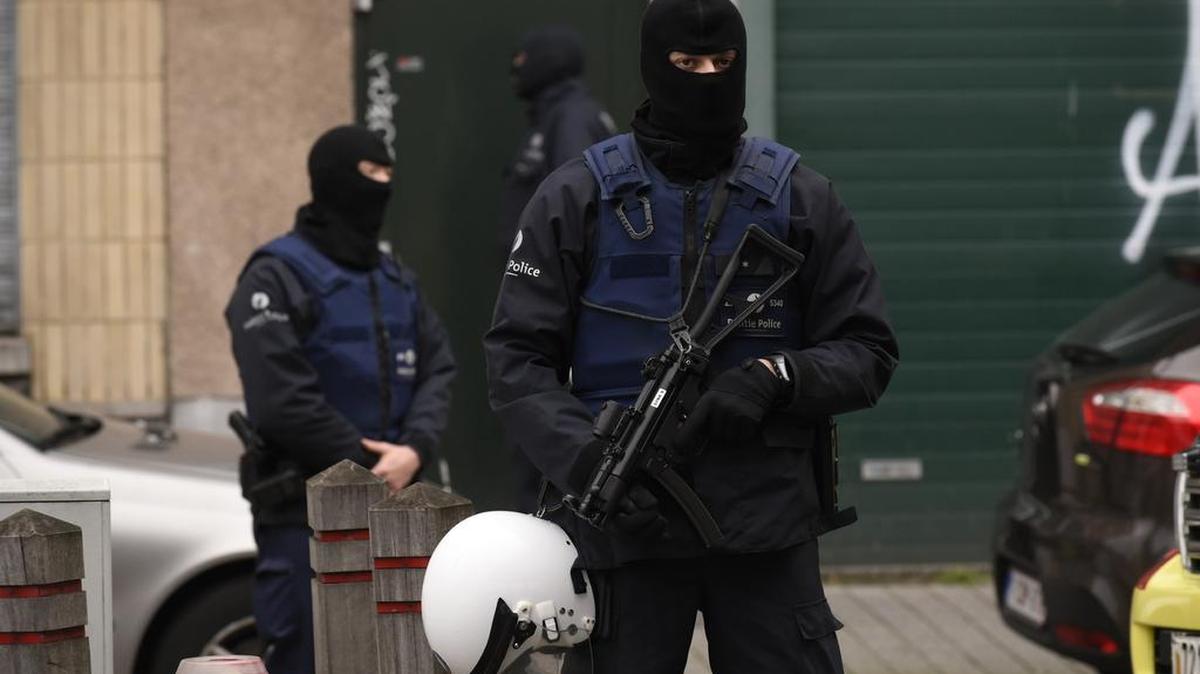 Agentes policiales de Bélgica vigilan el perímetro durante un allanamiento en el distrito Molenbeek de Bruselas, el lunes.