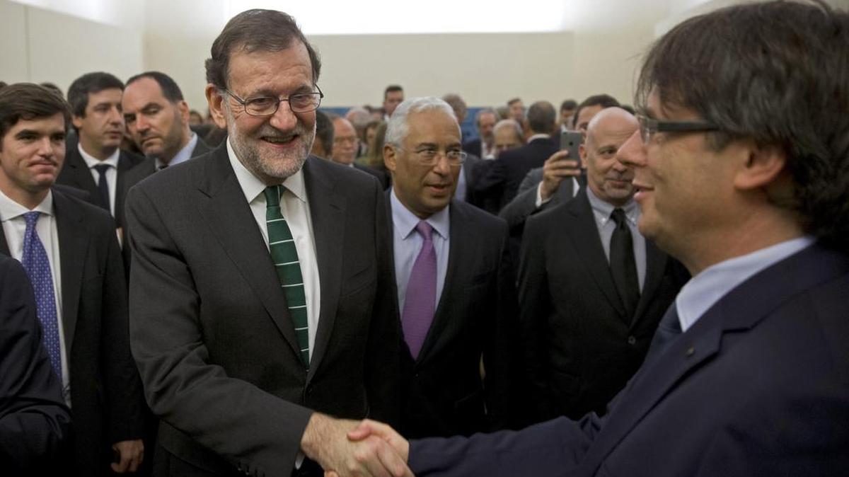 El jefe del Gobierno, Mariano Rajoy (i), y el presidente de la Generalitat de Cataluña, Carles Puigdemont (d), se saludan en Oporto en el acto de inauguración de una exposición del pintor catalán Joan Miró.