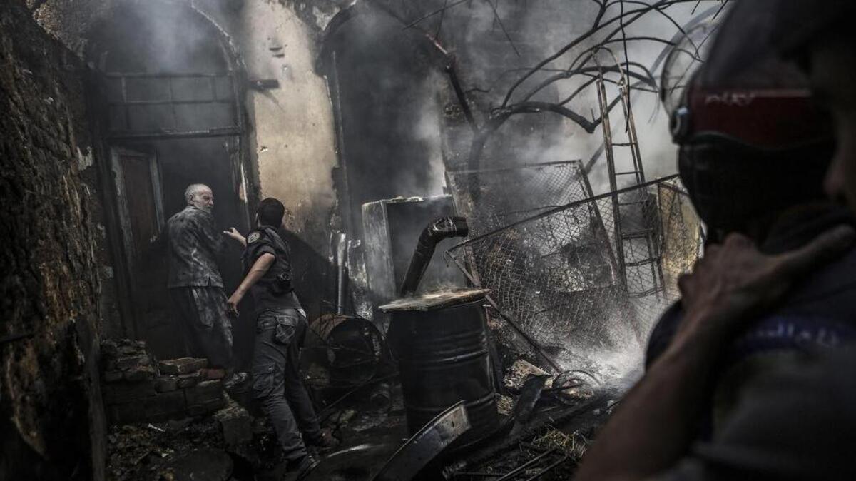 Los bomberos extinguen un incendio tras un ataque aéreo de las fuerzas leales al gobierno sirio, en las afueras de Damasco, Siria, el 11 de septiembre de 2016. Los ataques vienen un día antes de un alto el fuego acordado entre Rusia y EE.UU..