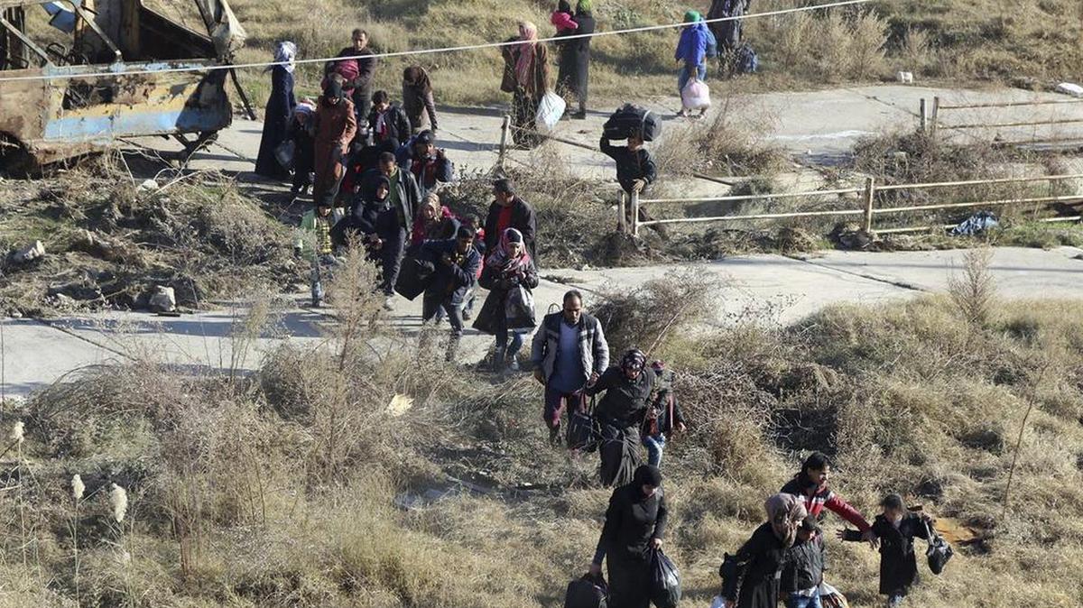 Un grupo de personas huyen de la parte este de Alepo hacia la zona de Sheikh Maqsoud, controlada por los soldados curdos.