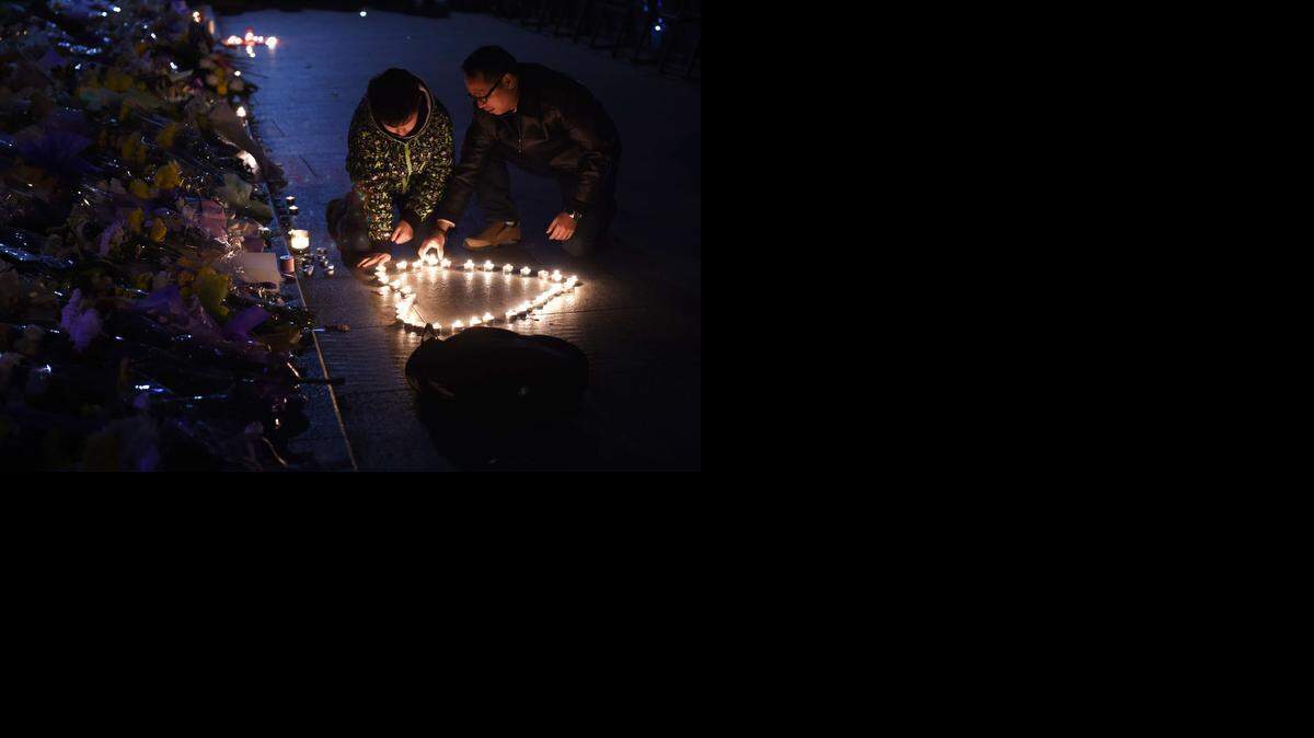 
Pocas horas después de las estampida, los agentes municipales prepararon una calle para que los habitantes depositen flores y enciendan velas. 

