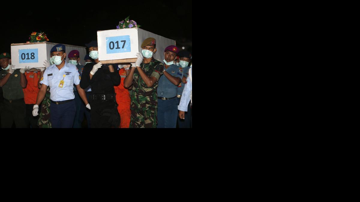
Soldados cargan los cuerpos de varias de las víctimas del avión de AirAsia siniestrado a su llegada al aeropuerto de Surabaya, Indonesia, el viernes.


