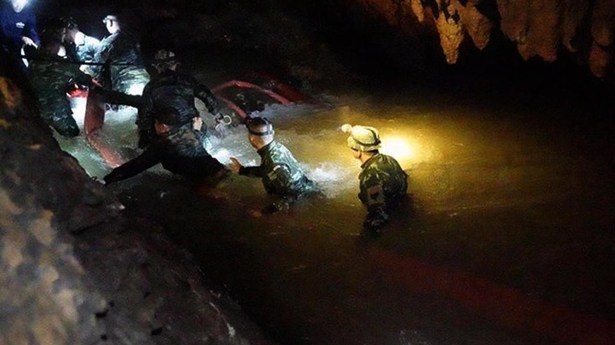Un equipo de rescatistas tailandeses caminan a través de una cueva inundada mientras contúan la búsqueda de une equipo infantil de fútbol.