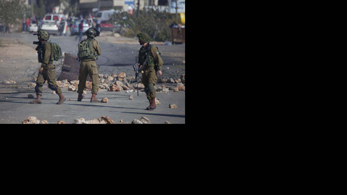 
Soldados israelies se enfrentan a un grupo de manifestantes palestinos el domingo luego del funeral de un adolescente que supuestamente murió el viernes por acciones del ejército de Netanyahu.


