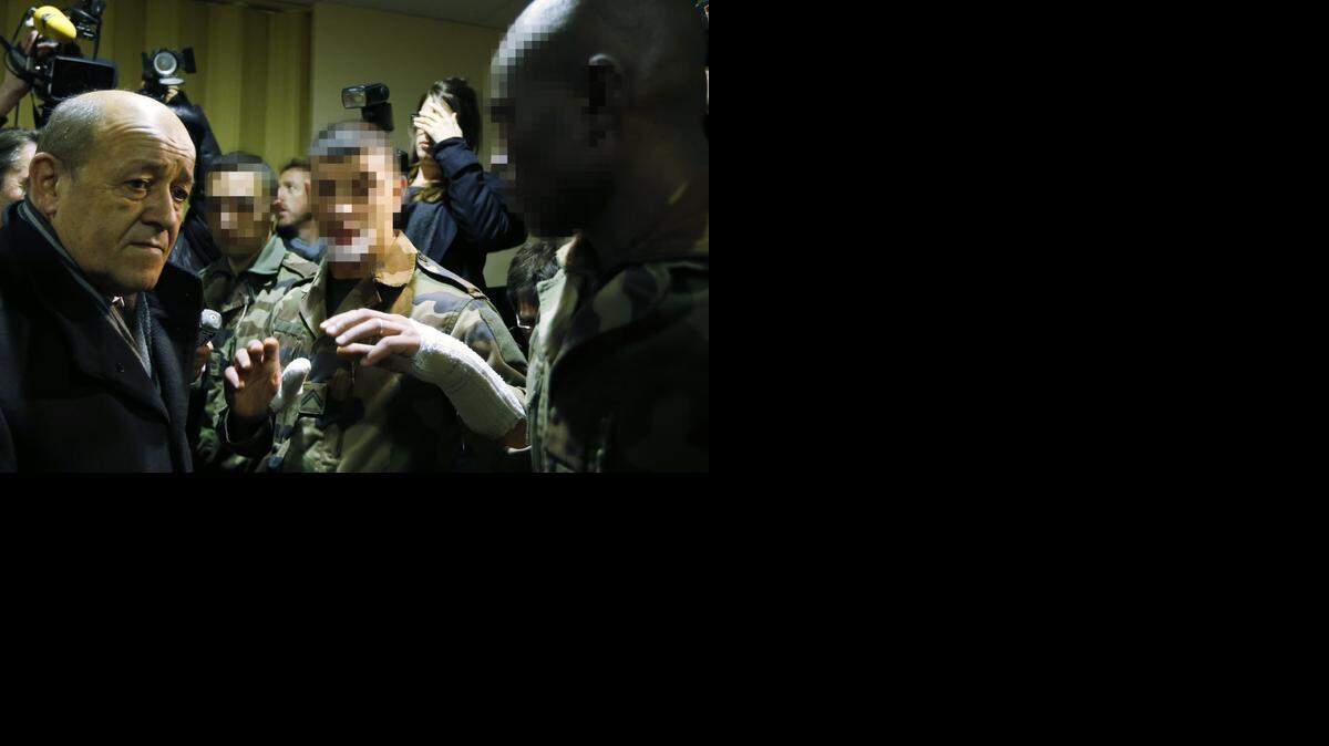 
El ministro francés de Defensa Jean-Yves Le Drian (izq.) habla con los soldados que recibieron heridas propiciadas por un atacante en el centro de la ciudad de Niza.


