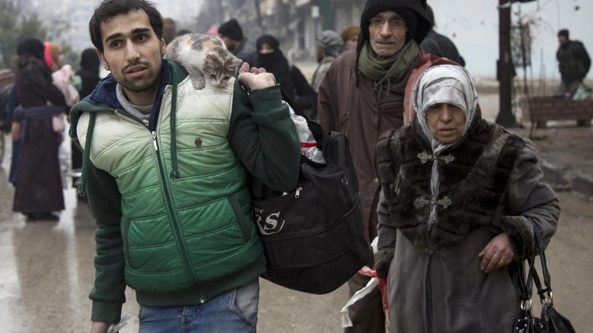 Sirios abandonan un sector que estaba dominado por rebeldes y se dirigen a un área controlada por el gobierno el martes en la ciudad siria de Alepo.