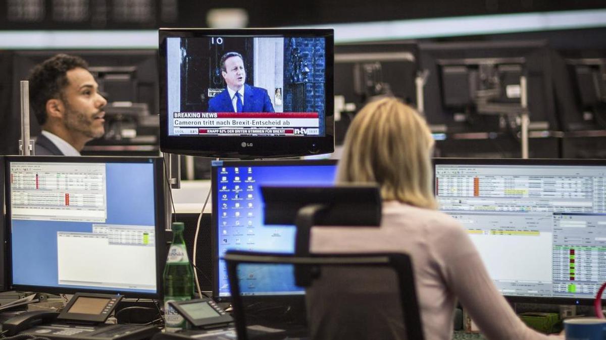 Una mujer observa la evolución del DAX 30 mientras escucha la comparecencia del primer ministro británico, David Cameron, en el parqué de Fráncfort (Alemania) hoy, 24 de junio de 2016.