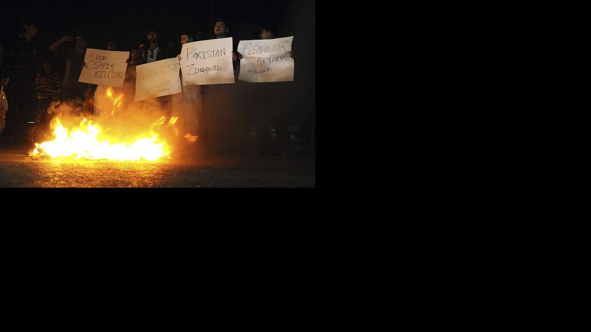 
Un grupo de pakistaníes musulmanes de la minoría chiita queman neumáticos y sostienen carteles durante un acto de protesta en contra del ataque perpetrado contra una mezquita de su comunidad, en Karachi, Pakistán, el viernes.
