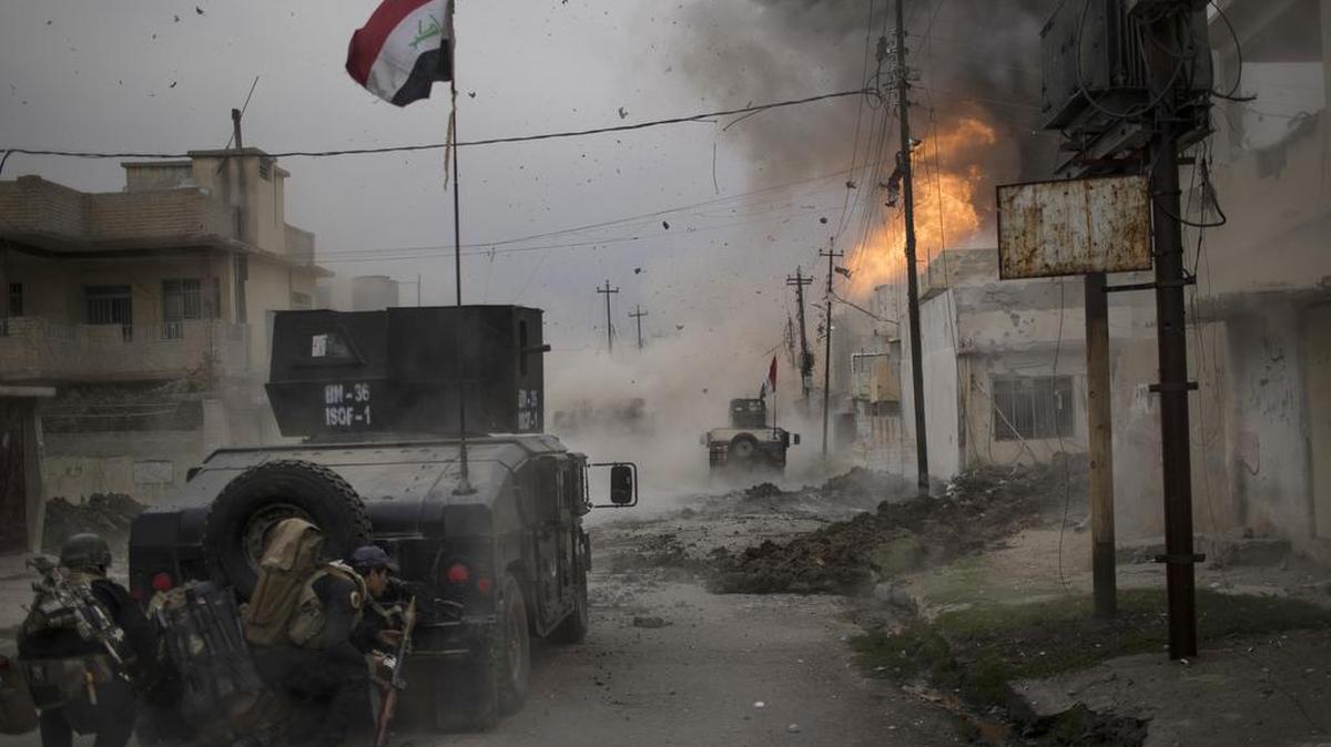 Un coche bomba explota junto a los vehículos blindados de las fuerzas iraquíes mientras avanzan hacia el territorio islámico controlado por los militantes en Mosul.