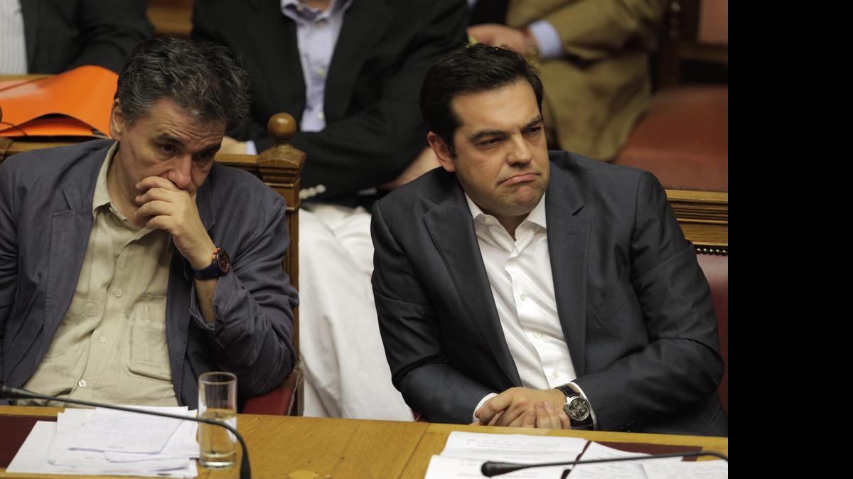 
El ministro de Finanzas de Grecia Euclid Tsakalotos (izq.) y el Primer Ministro de Grecia Alexis Tsipras, el miércoles, durante una sesión parlamentaria en Atenas, Grecia. 
