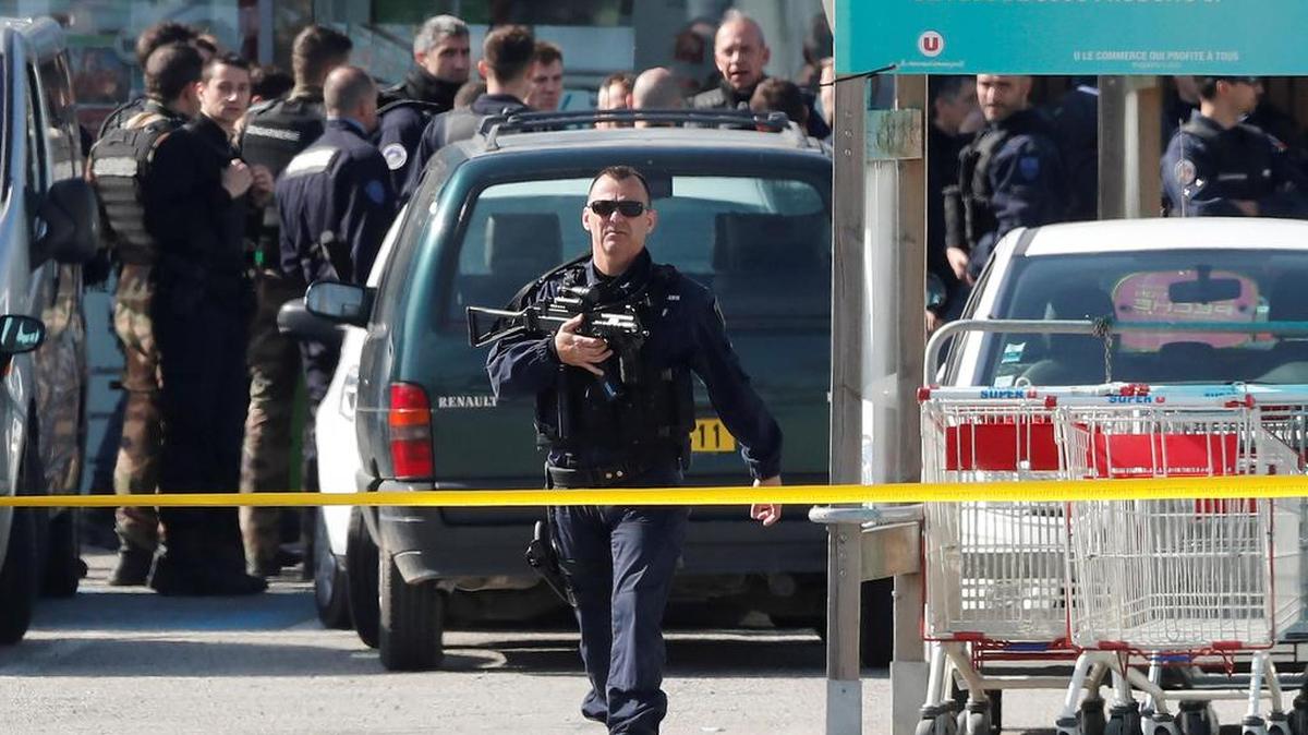 Dos efectivos de la Gendarmería Nacional francesa vigilan frente al supermercado de la cadena "Système U" donde se ha llevado a cabo una toma de rehenes en un supuesto acto terrorista en Trèbes, Francia, el 23 de marzo del 2018.