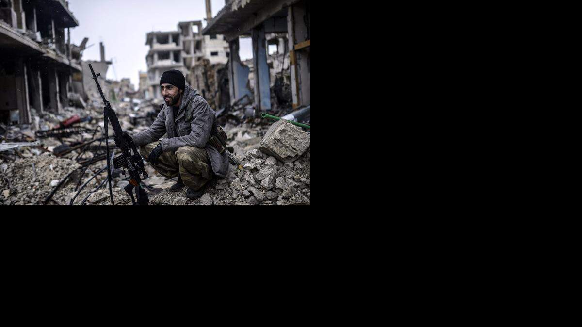 
El francotirador kurdo Musa sonríe satisfecho luego de que sus fuerzas retomaran la ciudad de Kobane, también llamada Ain al-Arab, que estaba en poder de yijadistas del Estado Islámico. 
