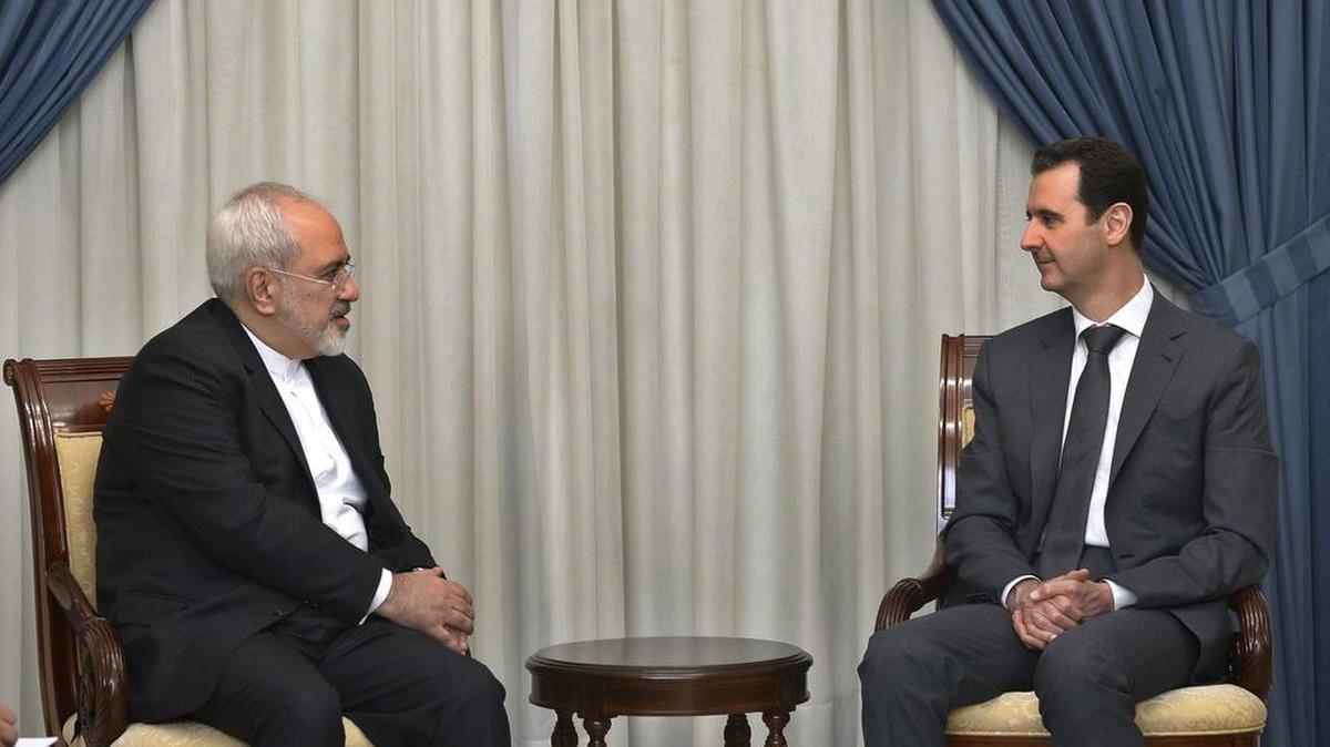 
El ministro iraní de Asuntos Exteriores, Mohamed Yavad Zarif (izq.), durante su encuentro con el presidente sirio Al Assad en Damasco, Siria, el martes.


