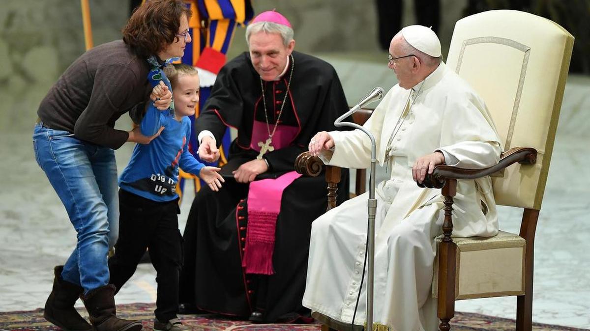 Un niño argentino de unos siete u ocho años accede al escenario del Aula Pablo VI mientras el papa Francisco (d) preside su audiencia general de los miércoles en el Vaticano, el 28 de noviembre de 2018.