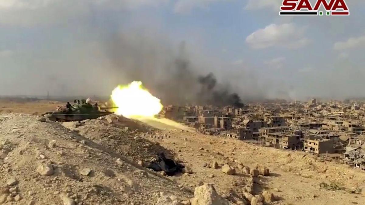 Un tanque del ejército sirio dispara en un combate contra posiciones de militantes del Estado Islámico, en Deir el-Zour, Siria.