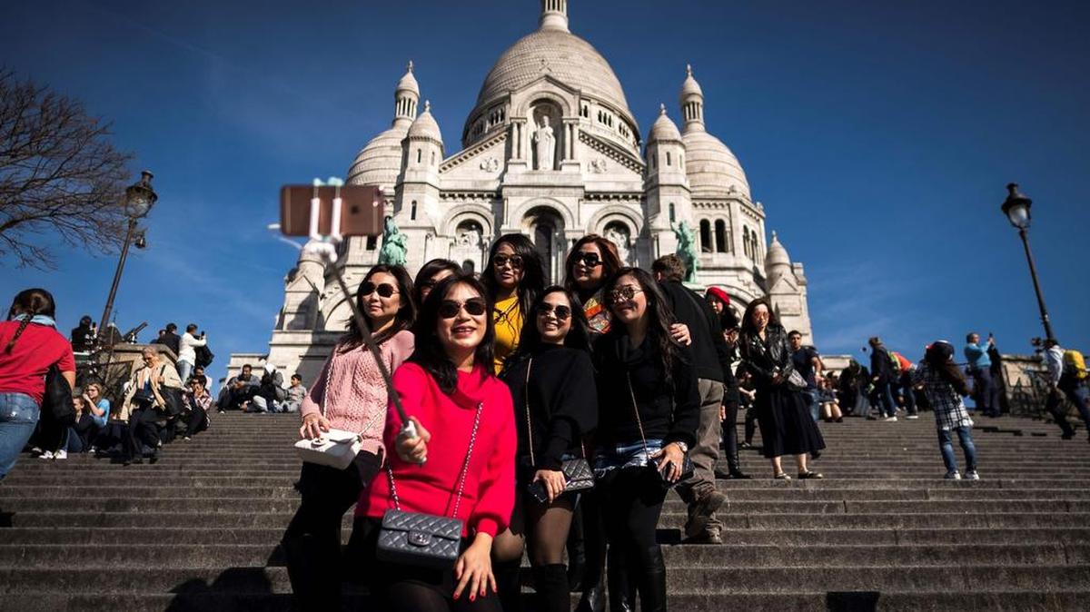 Un grupo de turistas se hace una foto ante la Basílica del Sagrado Corazón en el parisino distrito de Montmatre en marzo.