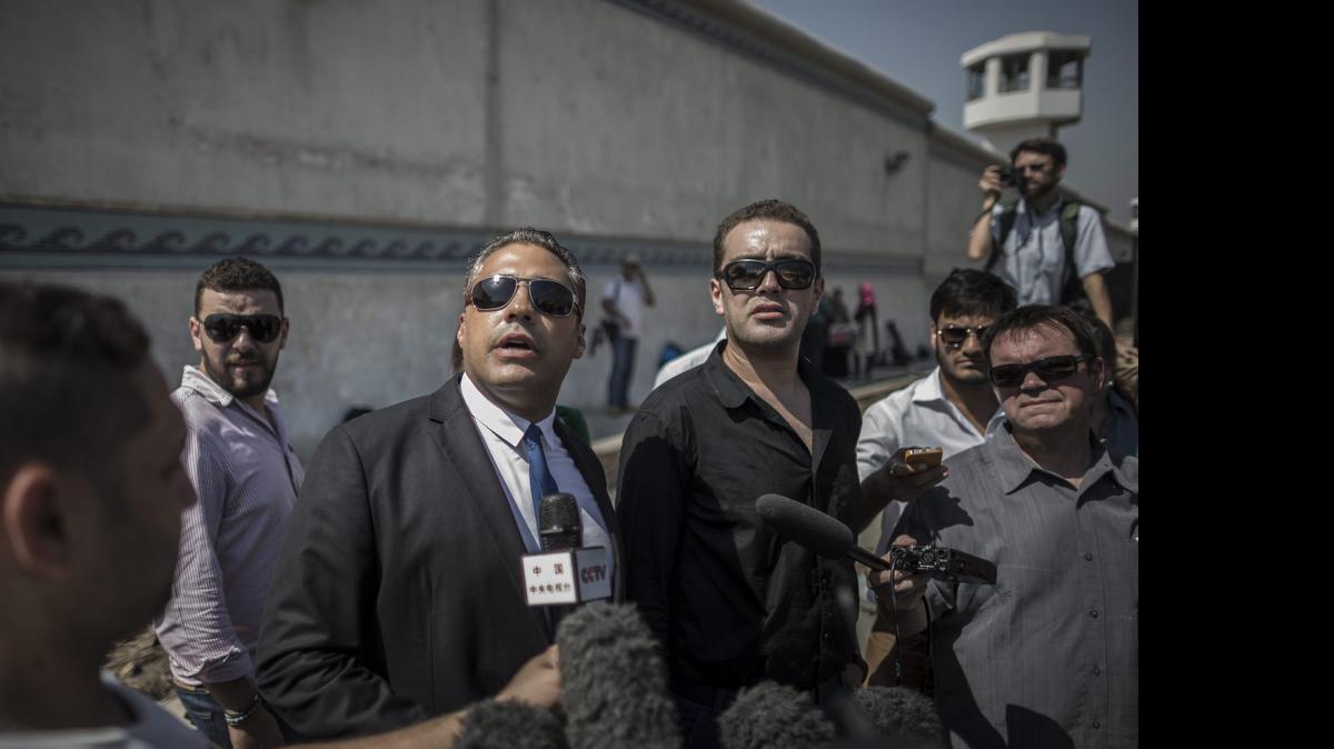 
El periodista Mohamed Fahmy (cen.) y su colega Baher Mahmoud (der), atienden a los medios de comunicación en la prisión de Tora en El Cairo, Egipto, el jueves.
