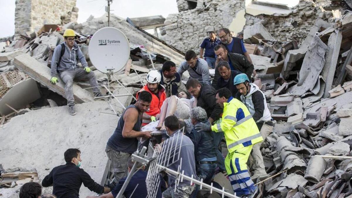 Una mujer herida es rescatada de entre los escombros de un edificio en Amatrice, en el centro de Italia, hoy, 24 de agosto de 2016.