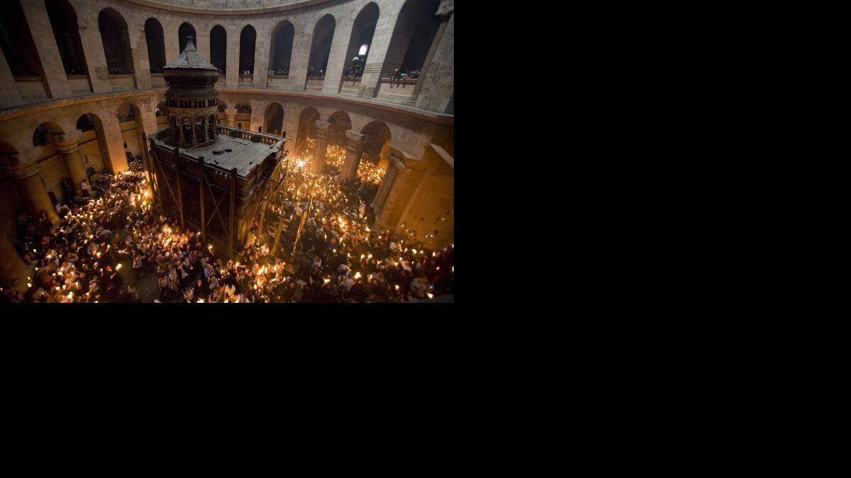 
Peregrinos cristianos ortodoxos encienden velas en la Iglesia del Santo Sepulcro en Jerusalén.

