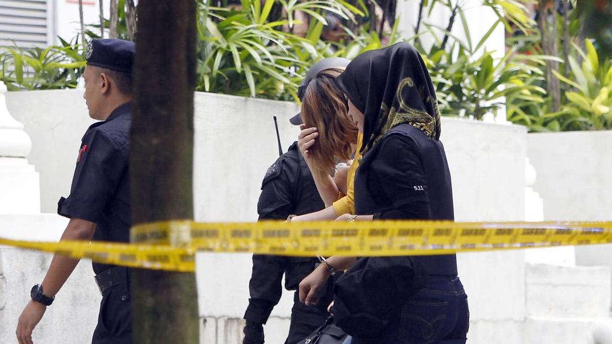 Una mujer sospechosa, centro, en la investigación de asesinato en curso es escoltada a la corte de Sepang en Sepang, Malasia, el miércoles, 1 de marzo de 2017.