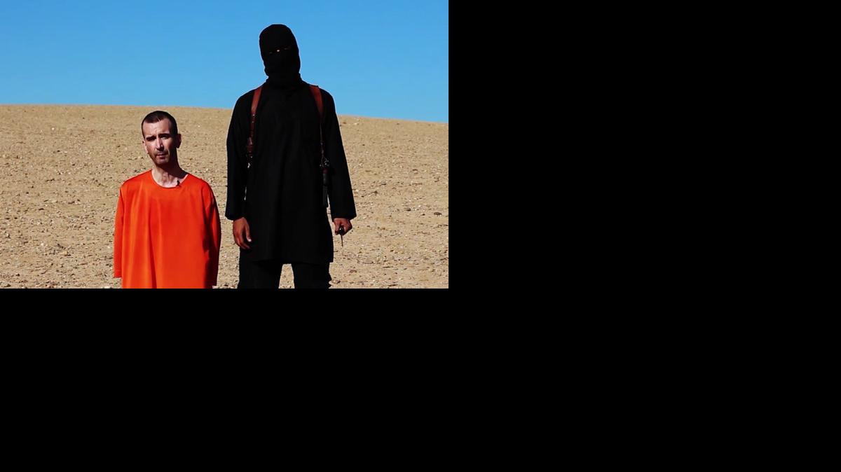 
La imagen tomada de un video online muestra al rehén británico y su verdugo.
